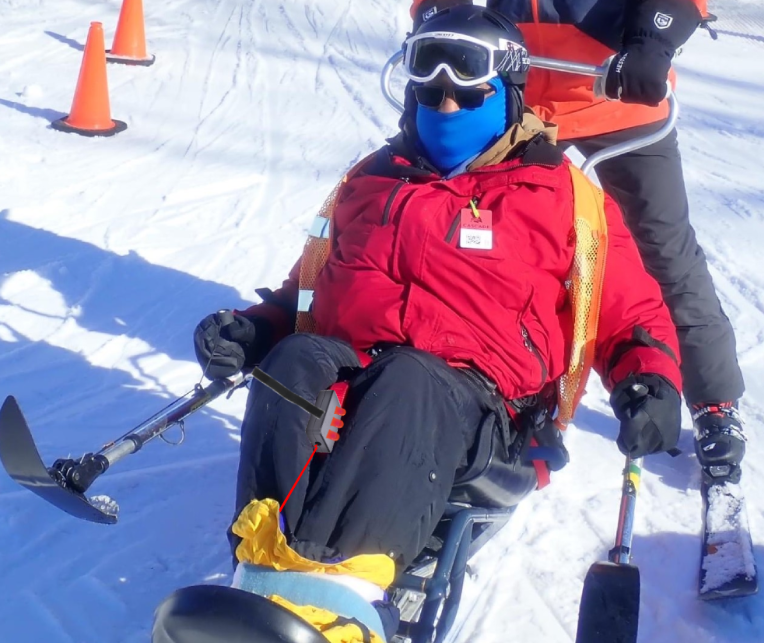 A person on a monoski. They have a device attached to their leg